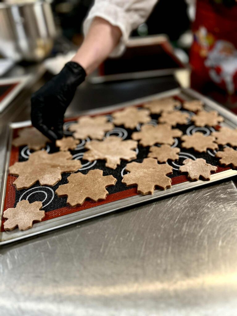 Zdjęcie przedstawiające układanie pierników na formę.