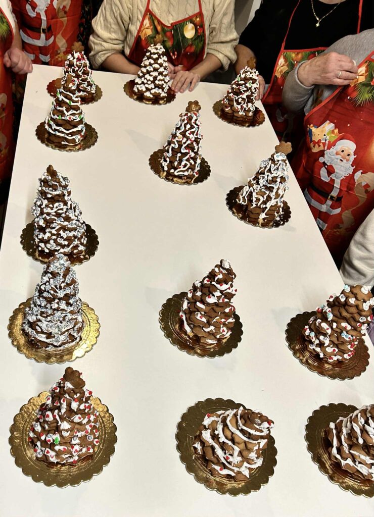 Zdjęcie przedstawiające choinki bożonarodzeniowe wykonane przez uczestników z wypieczonych wcześniej pierników