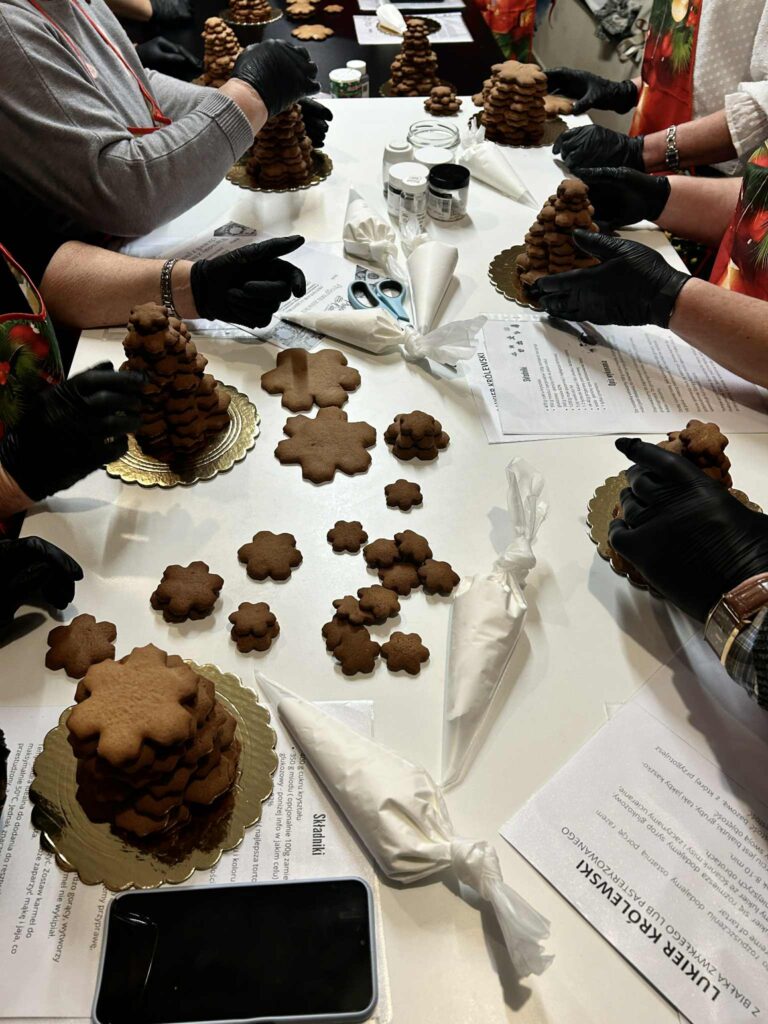 Zdjęcie przedstawiające moment składania choinek z upieczonych już pierników